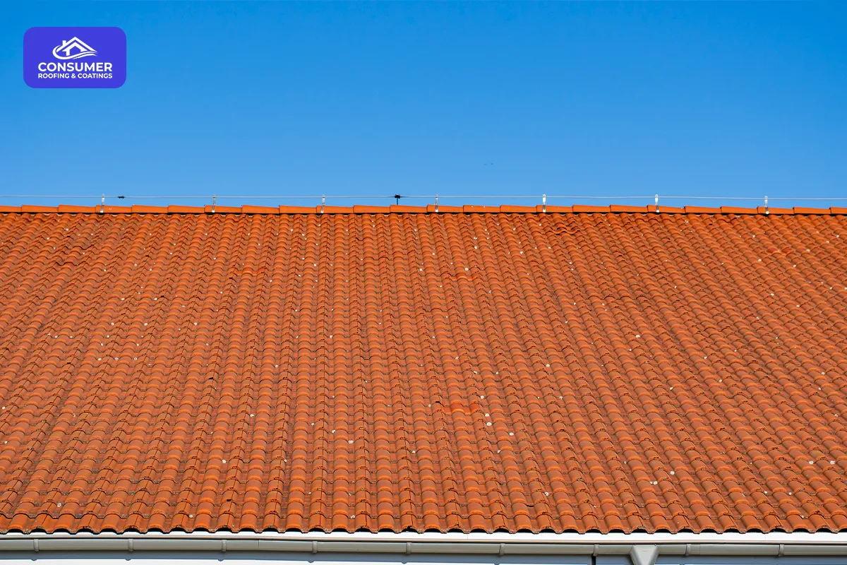 Orange tiled roof beneath a blue sky, with the Consumer Roofing logo